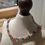 This is a bead necklace that consists of colorful peanut shape beads. It's as colorful as rainbow.