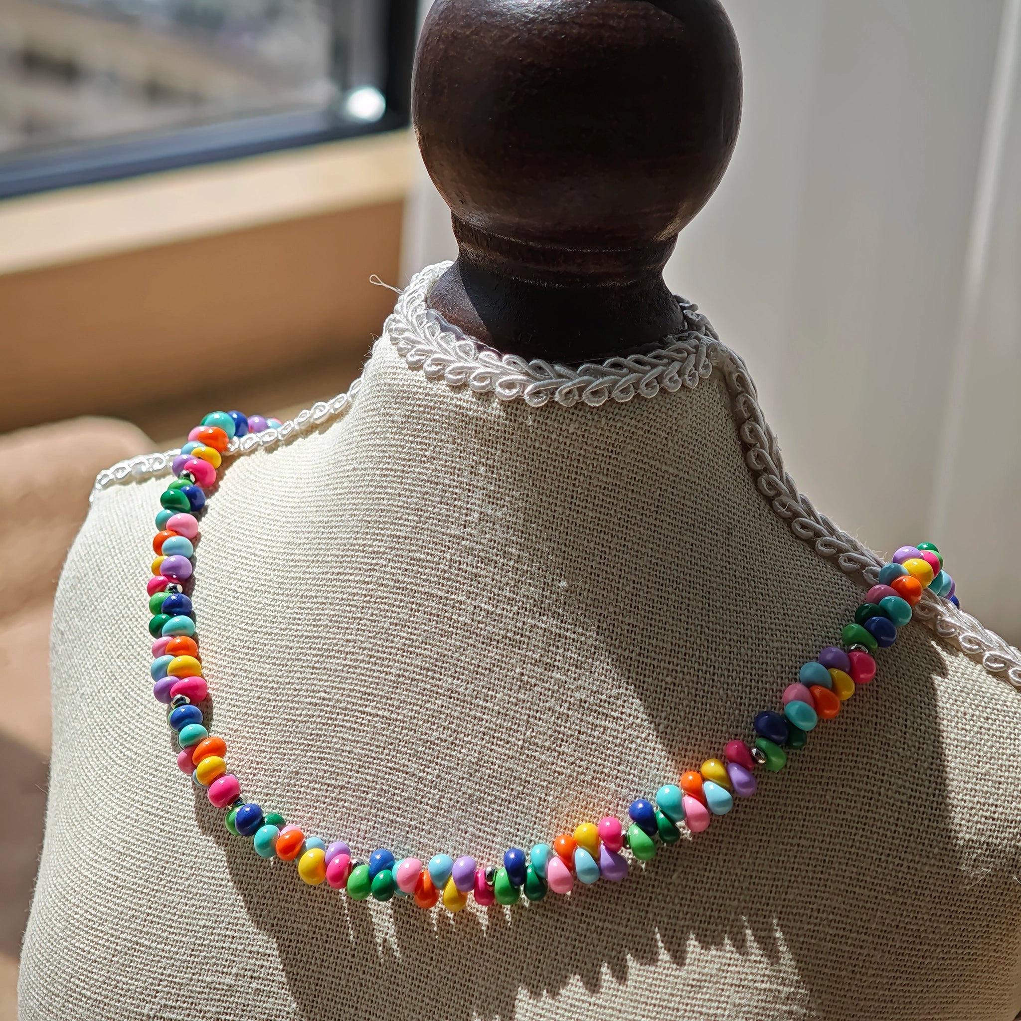 This is a bead necklace that consists of colorful peanut shape beads. It's as colorful as rainbow.