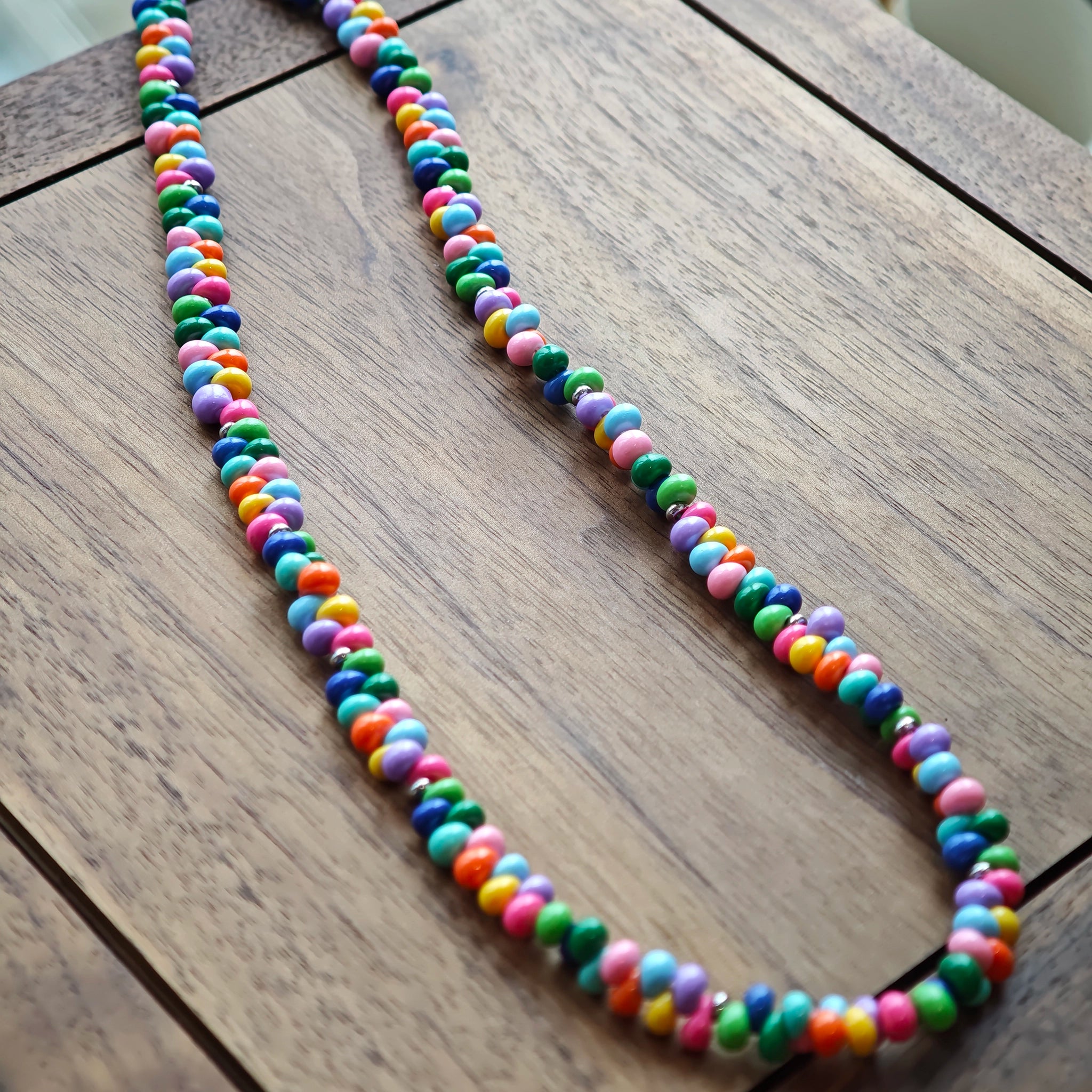 This is a bead necklace that consists of colorful peanut shape beads. It's as colorful as rainbow.