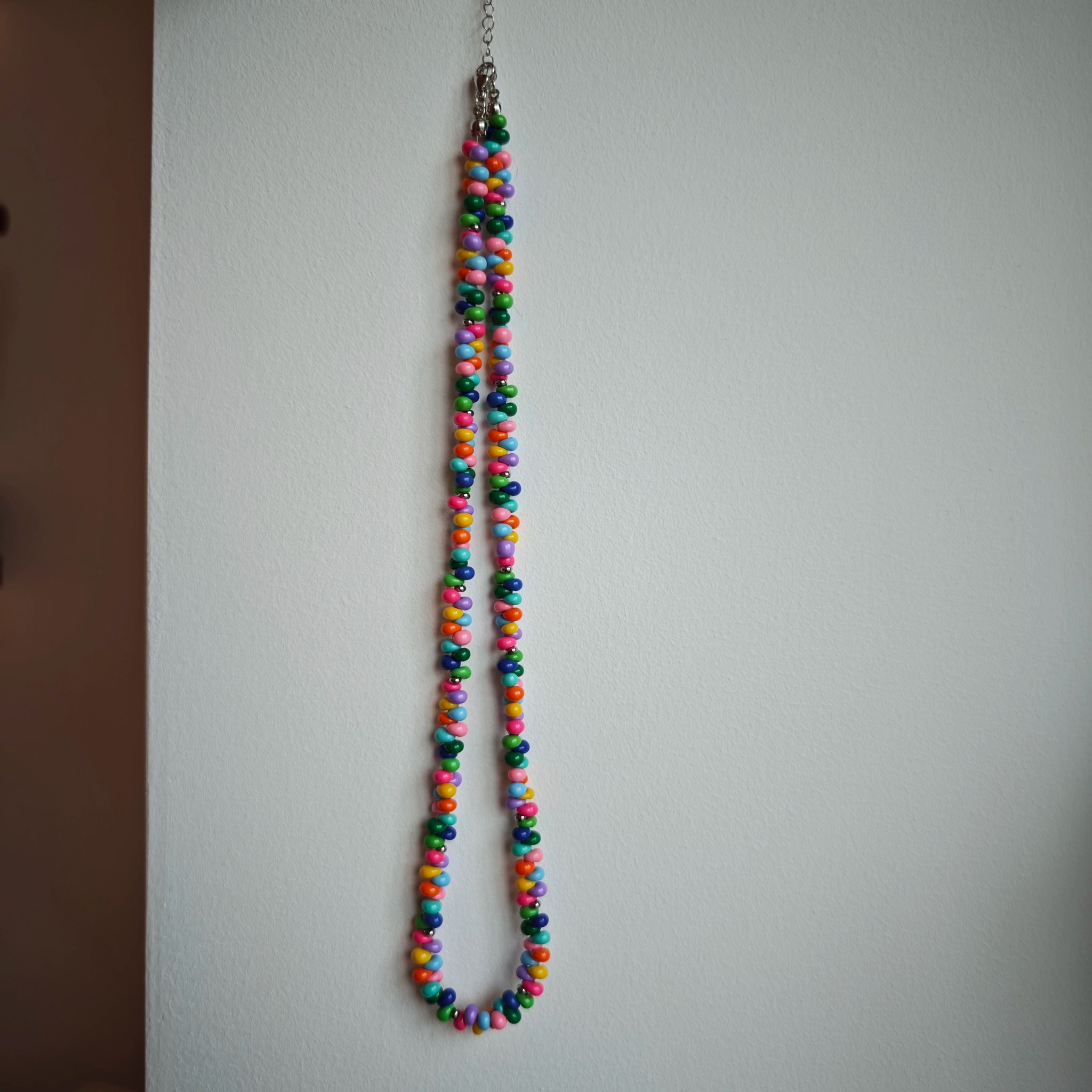 This is a bead necklace that consists of colorful peanut shape beads. It's as colorful as rainbow.