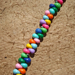 This is a bead necklace that consists of colorful peanut shape beads. It's as colorful as rainbow.