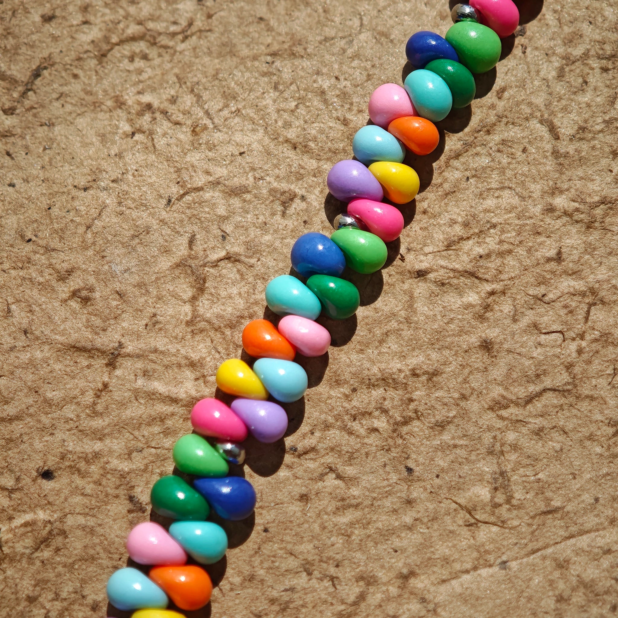 This is a bead necklace that consists of colorful peanut shape beads. It's as colorful as rainbow.