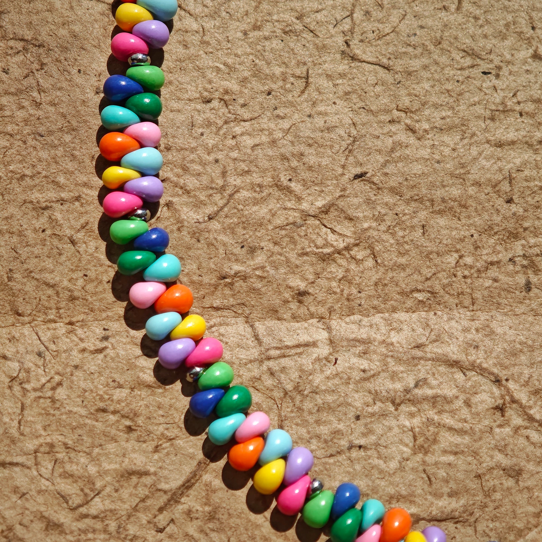 This is a bead necklace that consists of colorful peanut shape beads. It's as colorful as rainbow.