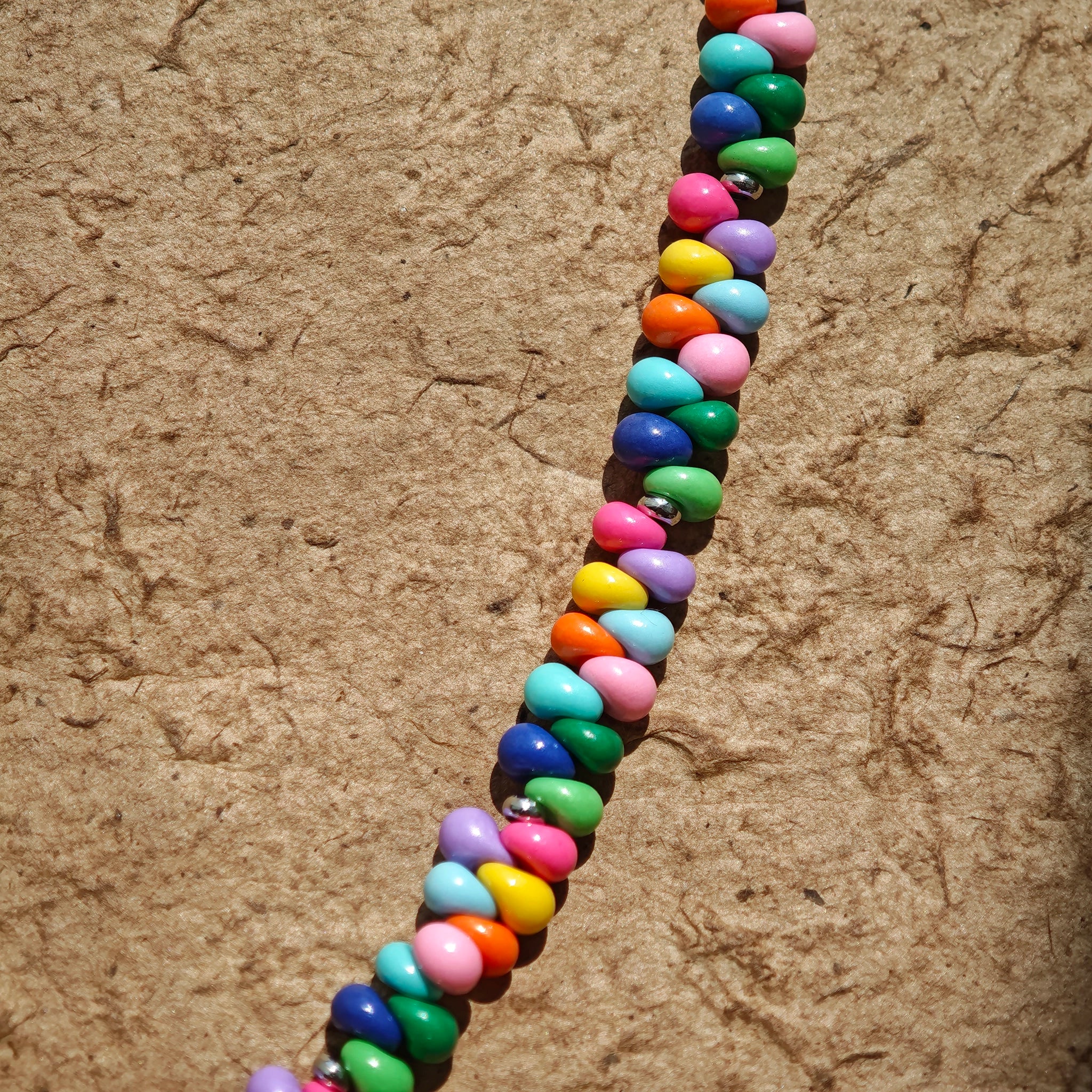 This is a bead necklace that consists of colorful peanut shape beads. It's as colorful as rainbow.