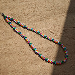 This is a bead necklace that consists of colorful peanut shape beads. It's as colorful as rainbow.