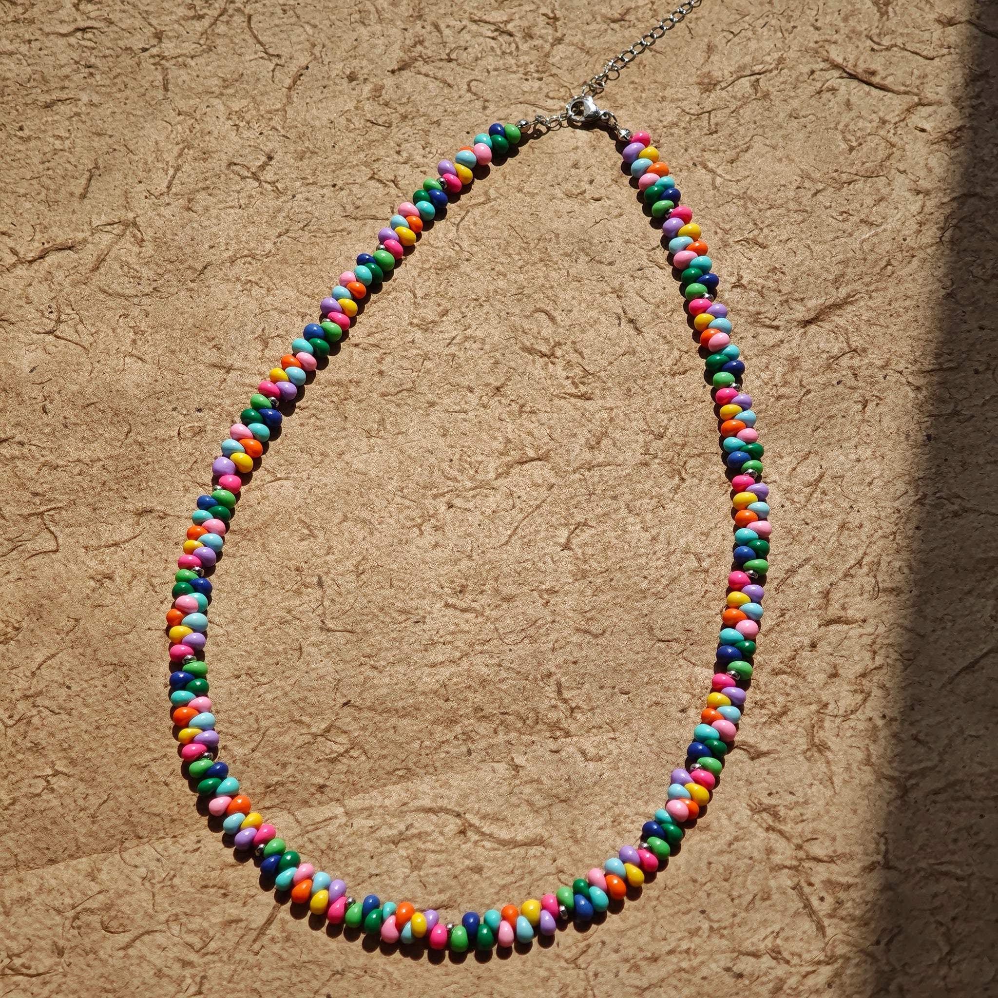 This is a bead necklace that consists of colorful peanut shape beads. It's as colorful as rainbow.