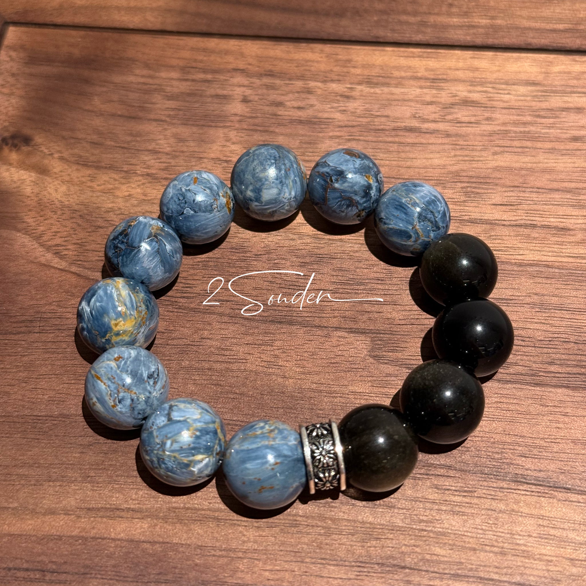 This is a bracelet consists of Blue Denim Pietersite and Golden Sheen Obsidian. The color of the bracelet is denim blue and black, accented by sleek silver spacer.