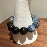 This is a bracelet consists of Blue Denim Pietersite and Golden Sheen Obsidian. The color of the bracelet is denim blue and black, accented by sleek silver spacer.