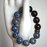 This is a bracelet consists of Blue Denim Pietersite and Golden Sheen Obsidian. The color of the bracelet is denim blue and black, accented by sleek silver spacer.