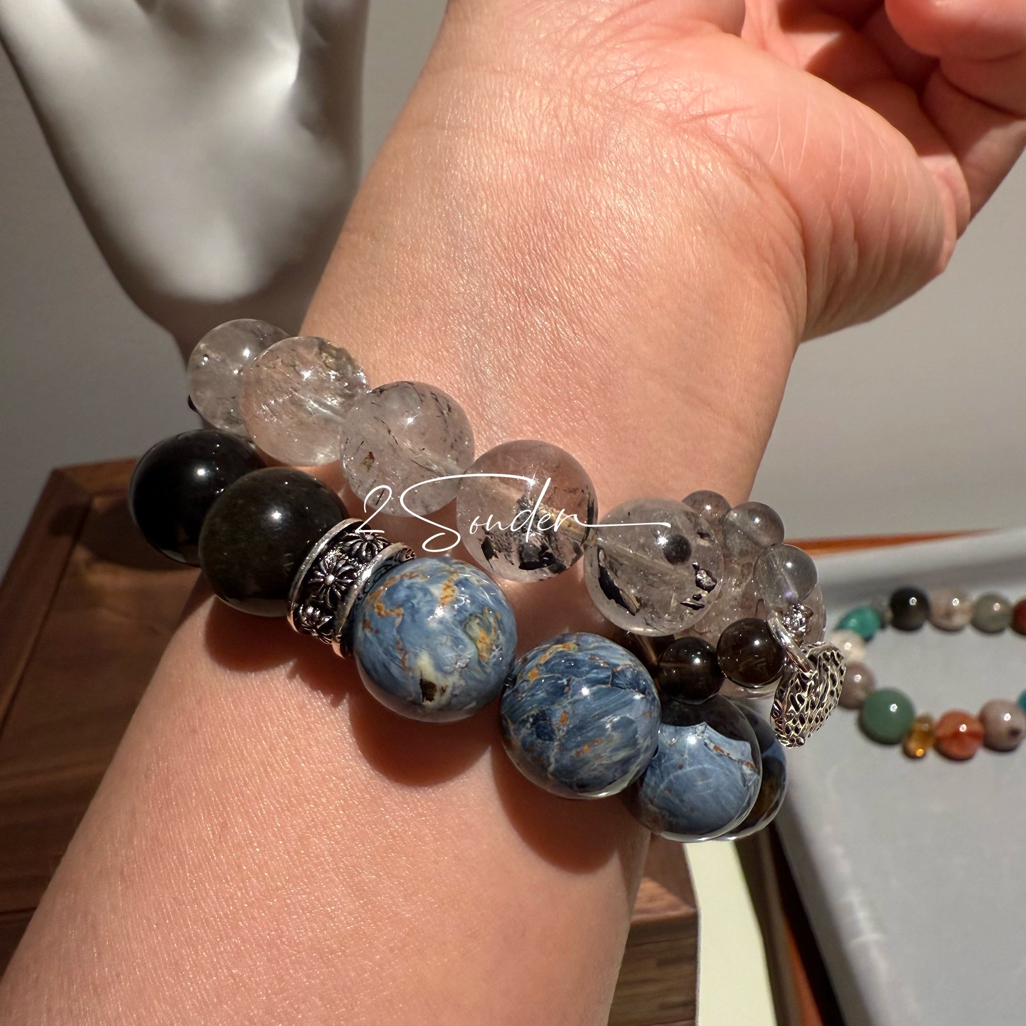 This is a bracelet consists of Blue Denim Pietersite and Golden Sheen Obsidian. The color of the bracelet is denim blue and black, accented by sleek silver spacer.