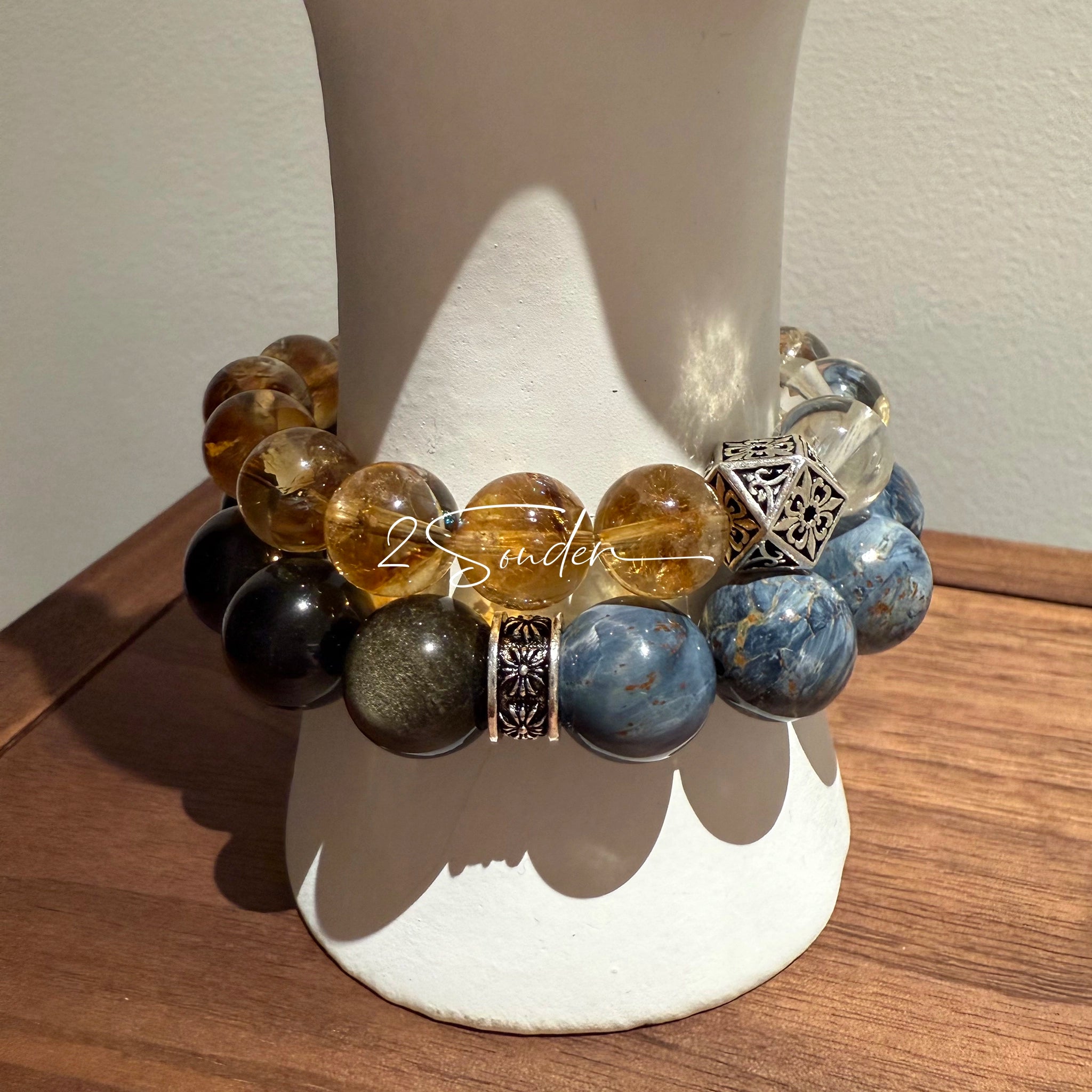 This is a bracelet consists of Blue Denim Pietersite and Golden Sheen Obsidian. The color of the bracelet is denim blue and black, accented by sleek silver spacer.