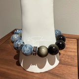 This is a bracelet consists of Blue Denim Pietersite and Golden Sheen Obsidian. The color of the bracelet is denim blue and black, accented by sleek silver spacer.