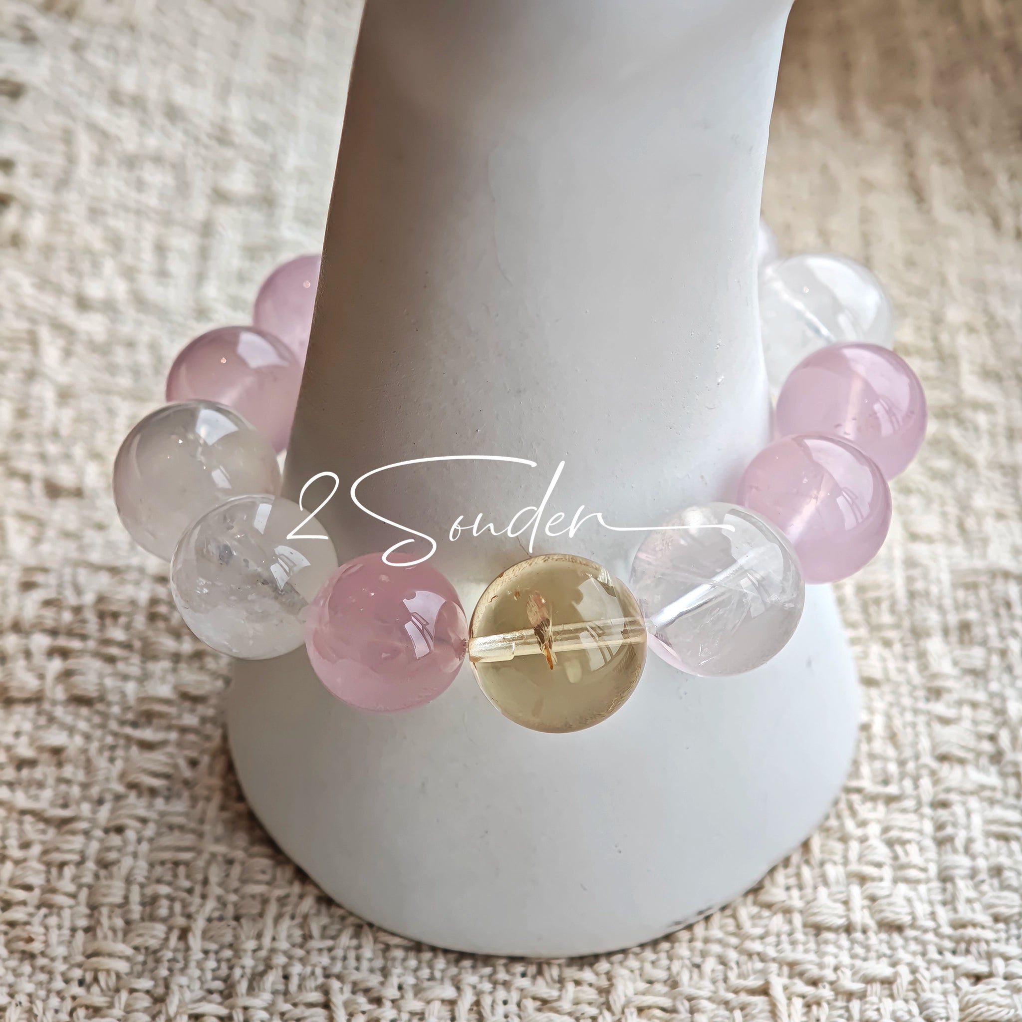 This natural crystal bracelet features a serene mix of white phantom quartz, soft rose quartz, and luminous citrine beads, creating a light, airy aesthetic. Adorned with delicate star-and-moon bodhi seed accents and a milky white chalcedony pendant, it adds a touch of gentle elegance to everyday wear.