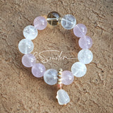 This natural crystal bracelet features a serene mix of white phantom quartz, soft rose quartz, and luminous citrine beads, creating a light, airy aesthetic. Adorned with delicate star-and-moon bodhi seed accents and a milky white chalcedony pendant, it adds a touch of gentle elegance to everyday wear.