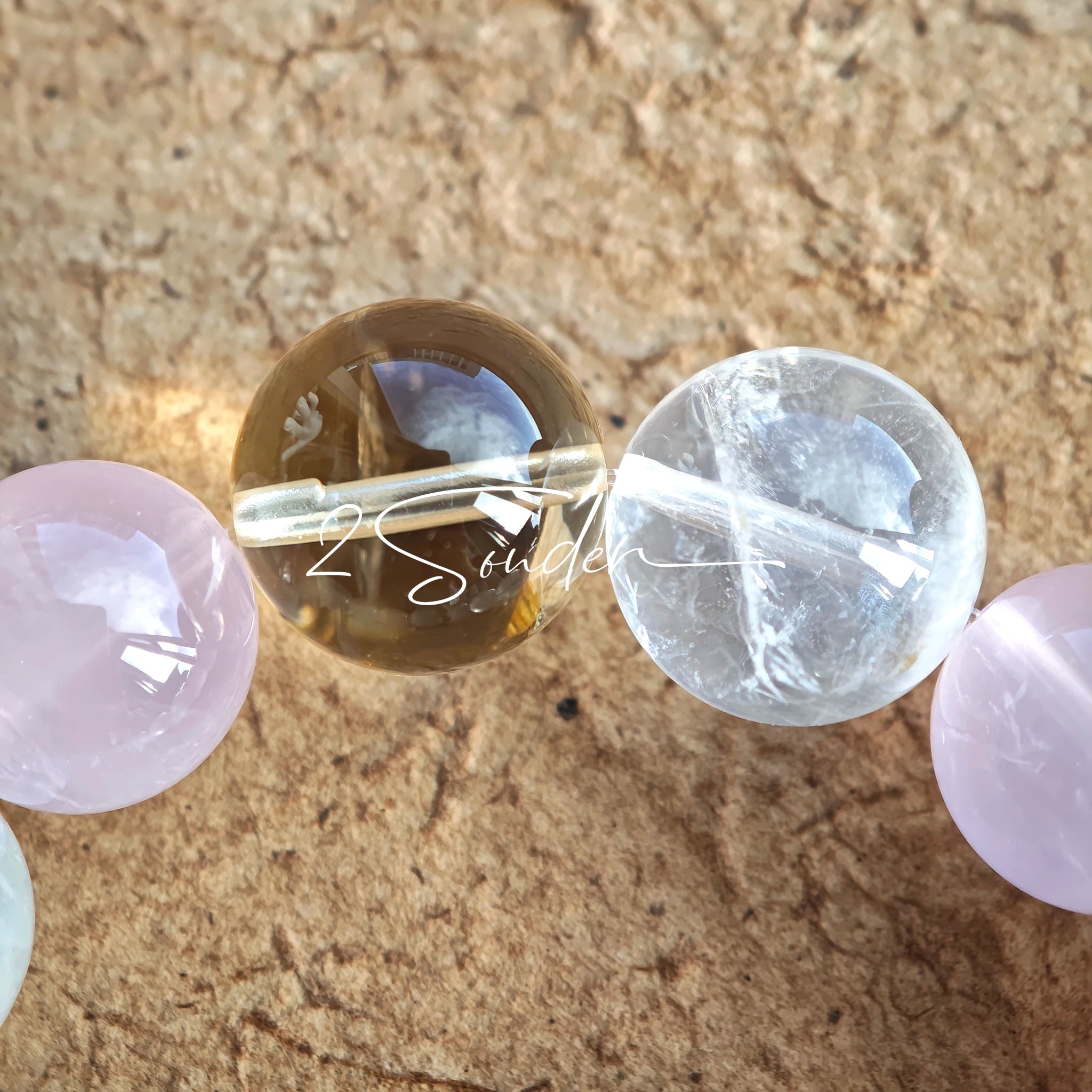 This natural crystal bracelet features a serene mix of white phantom quartz, soft rose quartz, and luminous citrine beads, creating a light, airy aesthetic. Adorned with delicate star-and-moon bodhi seed accents and a milky white chalcedony pendant, it adds a touch of gentle elegance to everyday wear.
