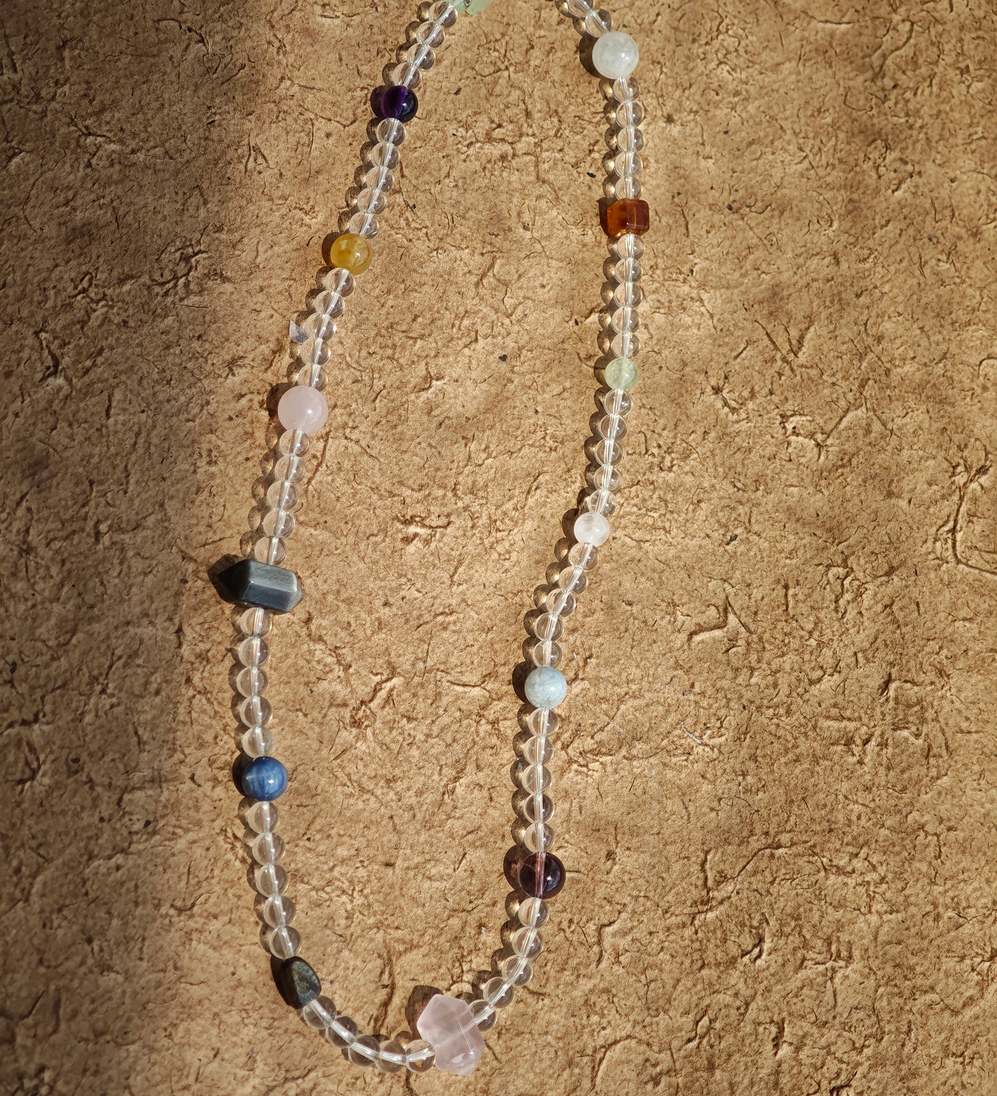 A multi-gemstone bracelet which is made with Silver Sheen Obsidian, Clear Quartz, Amethyst, Rose Quartz, Kyanite, Citrine, and Prehnite, etc. It’s also a necklace.