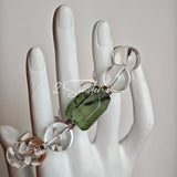 This stunning bracelet is crafted with a strand of perfectly round, high-clarity clear quartz beads, showcasing exceptional transparency and a brilliant, glass-like luster. At its center sits a striking free-form green gemstone accent, its natural inclusions and unique cut adding a one-of-a-kind, organic touch. The two stones are elegantly separated by delicate silver-toned decorative spacers, creating a balanced, sophisticated design that blends minimalist clarity with bold natural beauty.