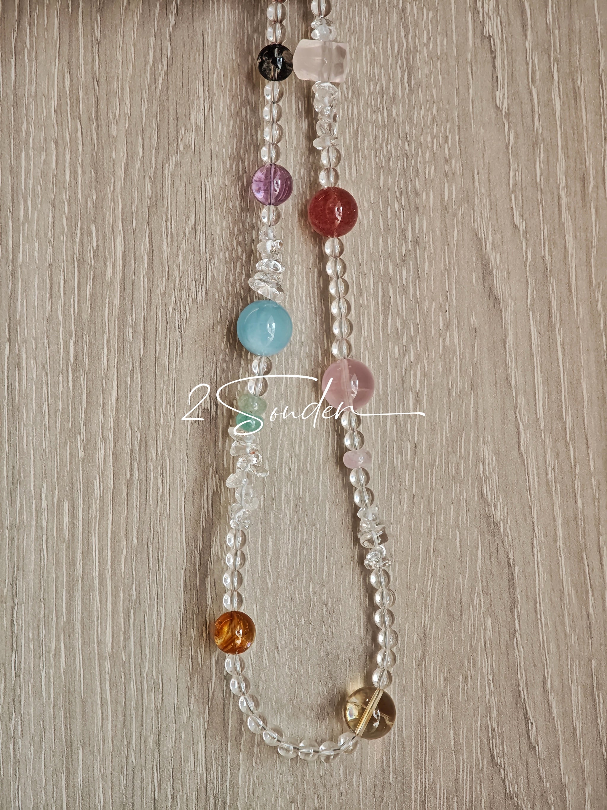This handcrafted gemstone necklace is a stunning blend of natural crystals, featuring sparkling Herkimer Diamonds, vibrant Brazilian Amethyst, rich Pigeon's Blood Strawberry Quartz, serene Aquamarine, sunny Citrine, and luminous clear quartz, each bead hand-selected for its one-of-a-kind beauty. Strung alongside polished clear quartz spacers and accent stones, the necklace balances bold, colorful statement beads with delicate, shimmering crystal details, creating a piece that feels both earthy and ethereal.