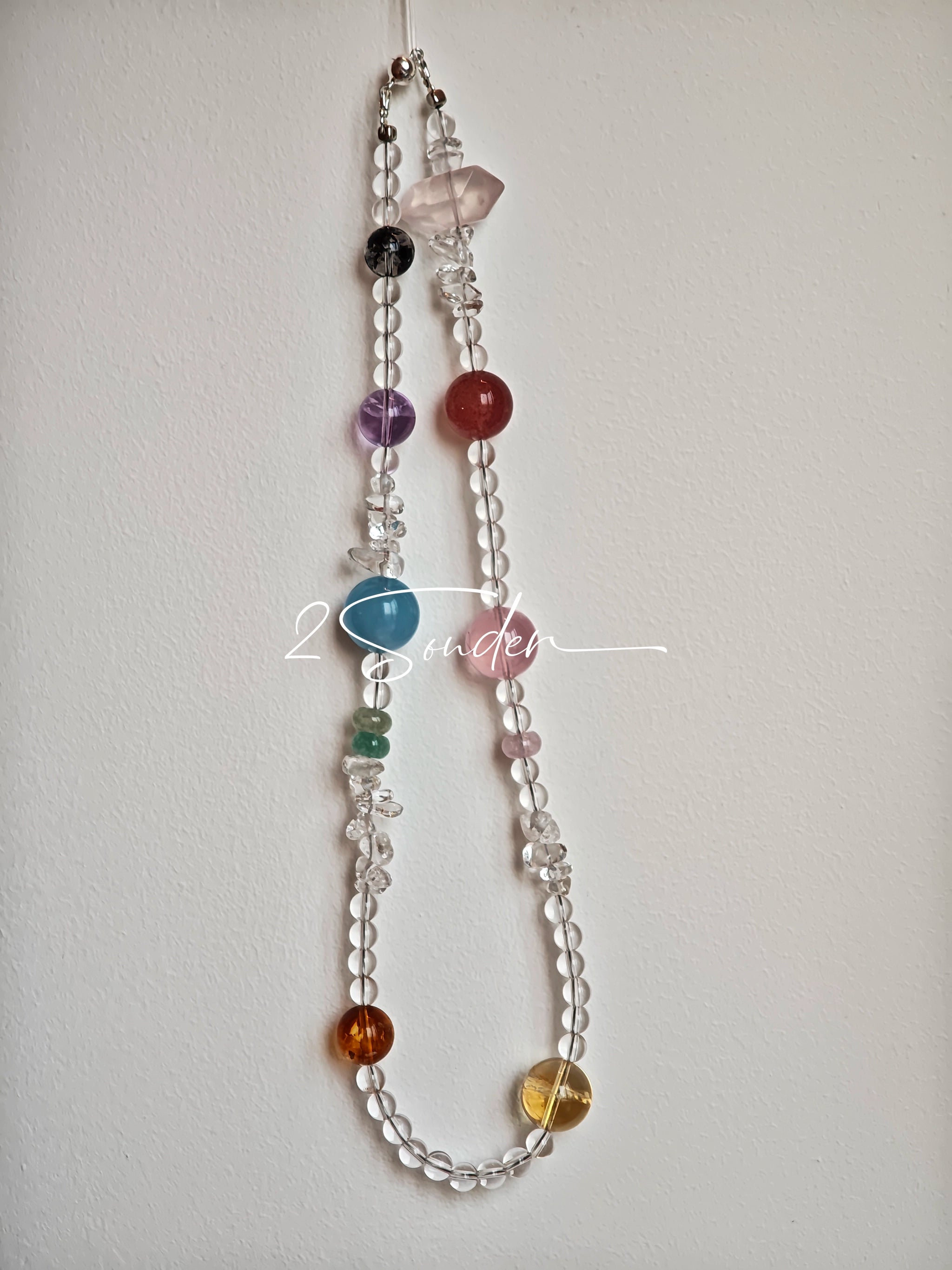 This handcrafted gemstone necklace is a stunning blend of natural crystals, featuring sparkling Herkimer Diamonds, vibrant Brazilian Amethyst, rich Pigeon's Blood Strawberry Quartz, serene Aquamarine, sunny Citrine, and luminous clear quartz, each bead hand-selected for its one-of-a-kind beauty. Strung alongside polished clear quartz spacers and accent stones, the necklace balances bold, colorful statement beads with delicate, shimmering crystal details, creating a piece that feels both earthy and ethereal.