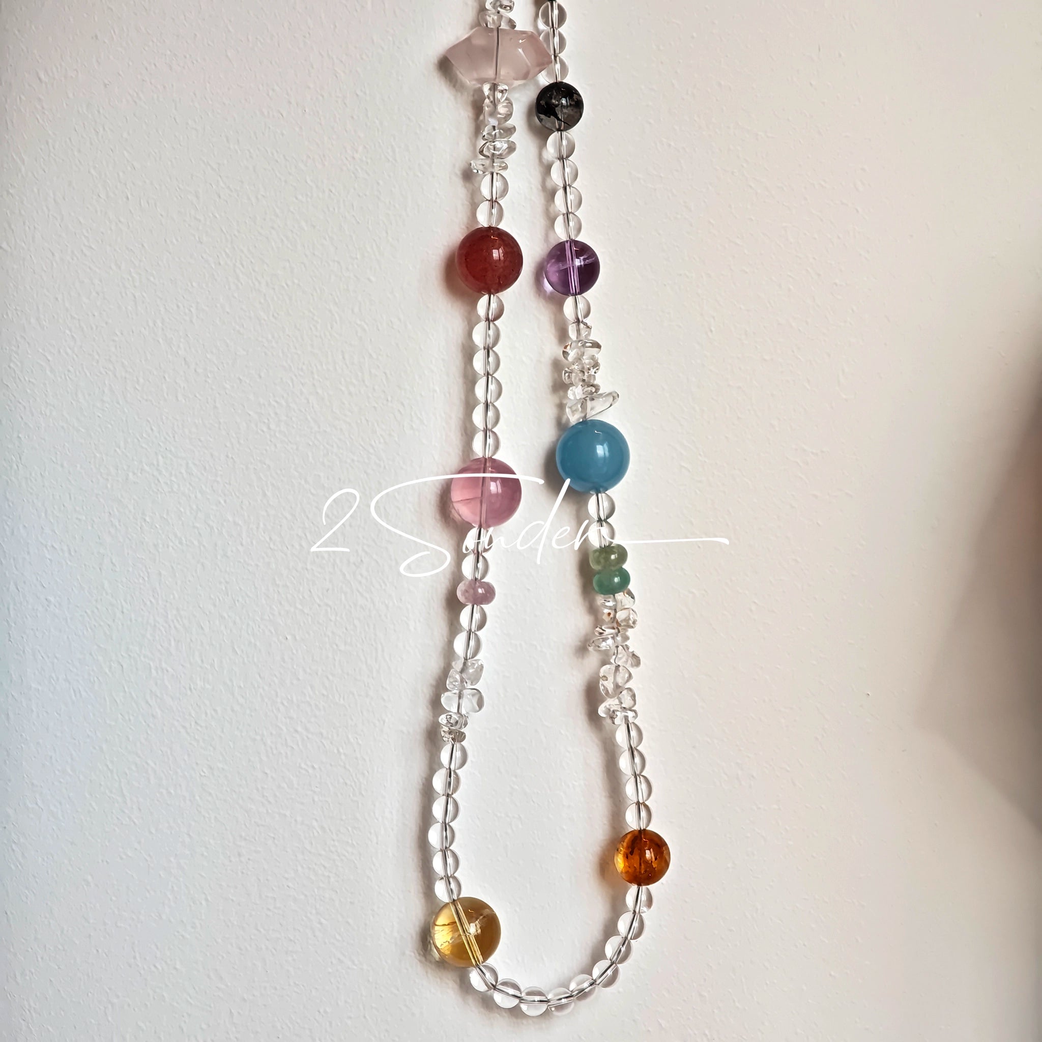 This handcrafted gemstone necklace is a stunning blend of natural crystals, featuring sparkling Herkimer Diamonds, vibrant Brazilian Amethyst, rich Pigeon's Blood Strawberry Quartz, serene Aquamarine, sunny Citrine, and luminous clear quartz, each bead hand-selected for its one-of-a-kind beauty. Strung alongside polished clear quartz spacers and accent stones, the necklace balances bold, colorful statement beads with delicate, shimmering crystal details, creating a piece that feels both earthy and ethereal.