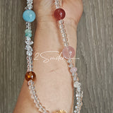 This handcrafted gemstone necklace is a stunning blend of natural crystals, featuring sparkling Herkimer Diamonds, vibrant Brazilian Amethyst, rich Pigeon's Blood Strawberry Quartz, serene Aquamarine, sunny Citrine, and luminous clear quartz, each bead hand-selected for its one-of-a-kind beauty. Strung alongside polished clear quartz spacers and accent stones, the necklace balances bold, colorful statement beads with delicate, shimmering crystal details, creating a piece that feels both earthy and ethereal.