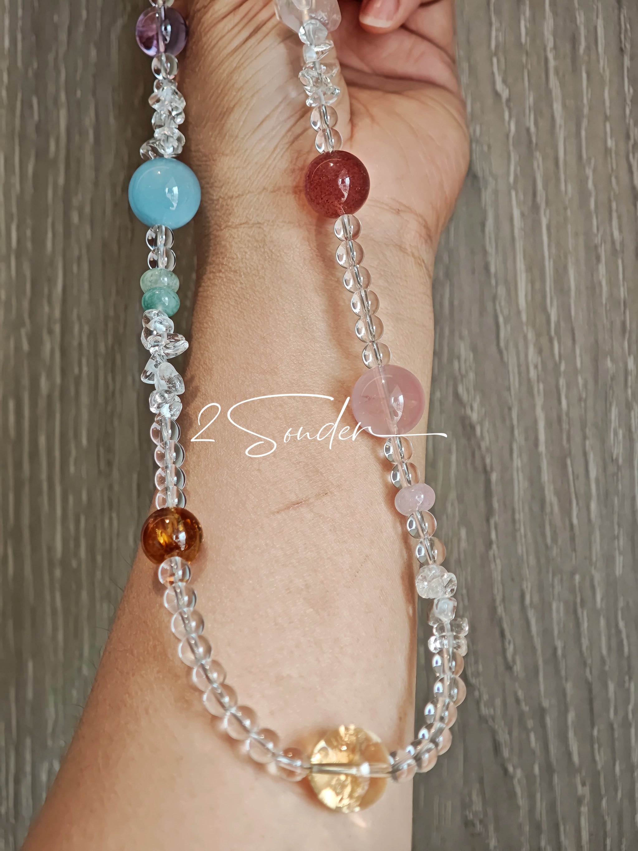 This handcrafted gemstone necklace is a stunning blend of natural crystals, featuring sparkling Herkimer Diamonds, vibrant Brazilian Amethyst, rich Pigeon's Blood Strawberry Quartz, serene Aquamarine, sunny Citrine, and luminous clear quartz, each bead hand-selected for its one-of-a-kind beauty. Strung alongside polished clear quartz spacers and accent stones, the necklace balances bold, colorful statement beads with delicate, shimmering crystal details, creating a piece that feels both earthy and ethereal.