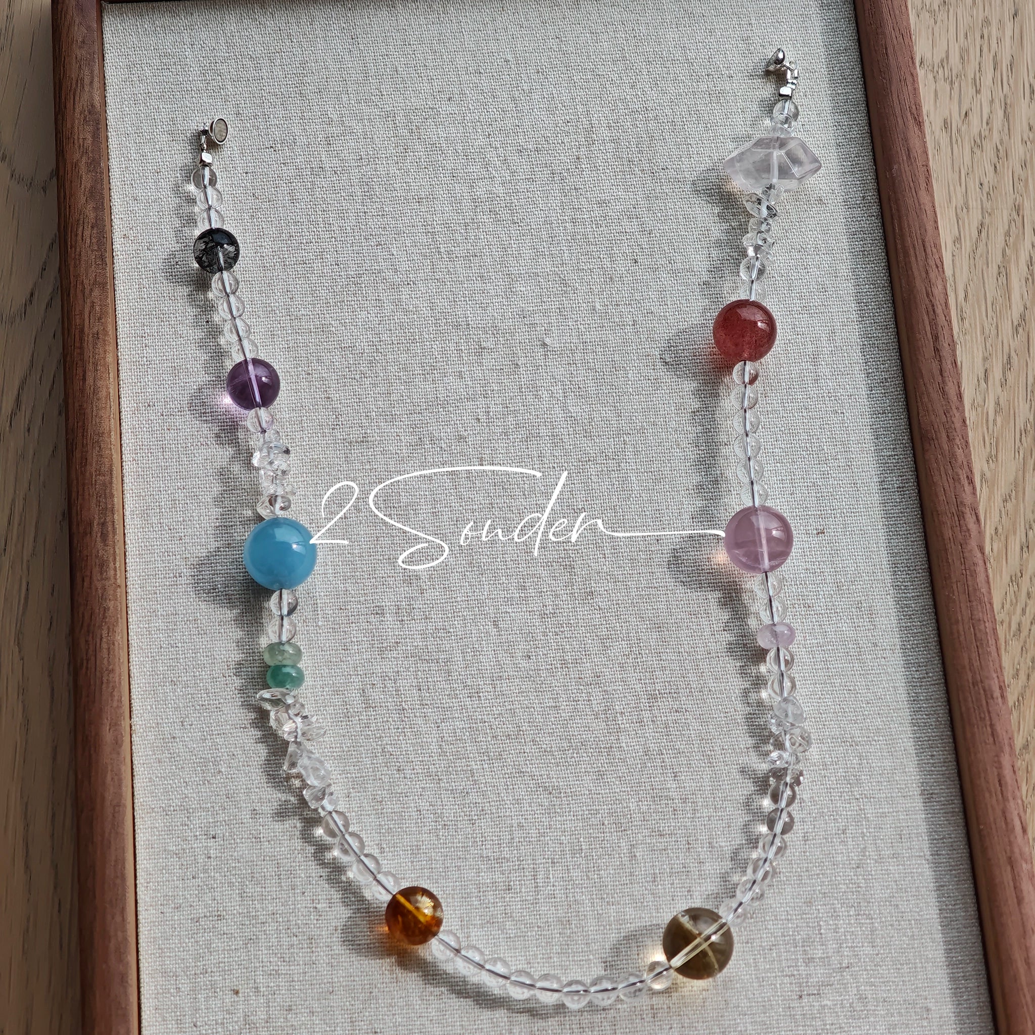 This handcrafted gemstone necklace is a stunning blend of natural crystals, featuring sparkling Herkimer Diamonds, vibrant Brazilian Amethyst, rich Pigeon's Blood Strawberry Quartz, serene Aquamarine, sunny Citrine, and luminous clear quartz, each bead hand-selected for its one-of-a-kind beauty. Strung alongside polished clear quartz spacers and accent stones, the necklace balances bold, colorful statement beads with delicate, shimmering crystal details, creating a piece that feels both earthy and ethereal.