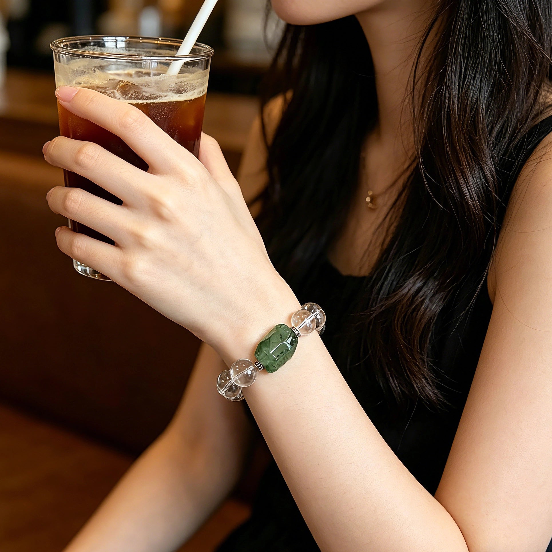 This stunning bracelet is crafted with a strand of perfectly round, high-clarity clear quartz beads, showcasing exceptional transparency and a brilliant, glass-like luster. At its center sits a striking free-form green gemstone accent, its natural inclusions and unique cut adding a one-of-a-kind, organic touch. The two stones are elegantly separated by delicate silver-toned decorative spacers, creating a balanced, sophisticated design that blends minimalist clarity with bold natural beauty.