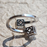This striking bypass ring showcases two large, brilliant cushion-cut clear stones held securely in classic four-prong settings. The elegant twisted band is lined with a row of sparkling accent Cubic Zirconia stones, delivering a high-end, light luxury aesthetic that instantly catches the eye.