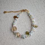 Consist of milky white and pale blue glass beads and shimmering crystal fragments, this beaded bracelet glows like sunlight dancing on icy shores.