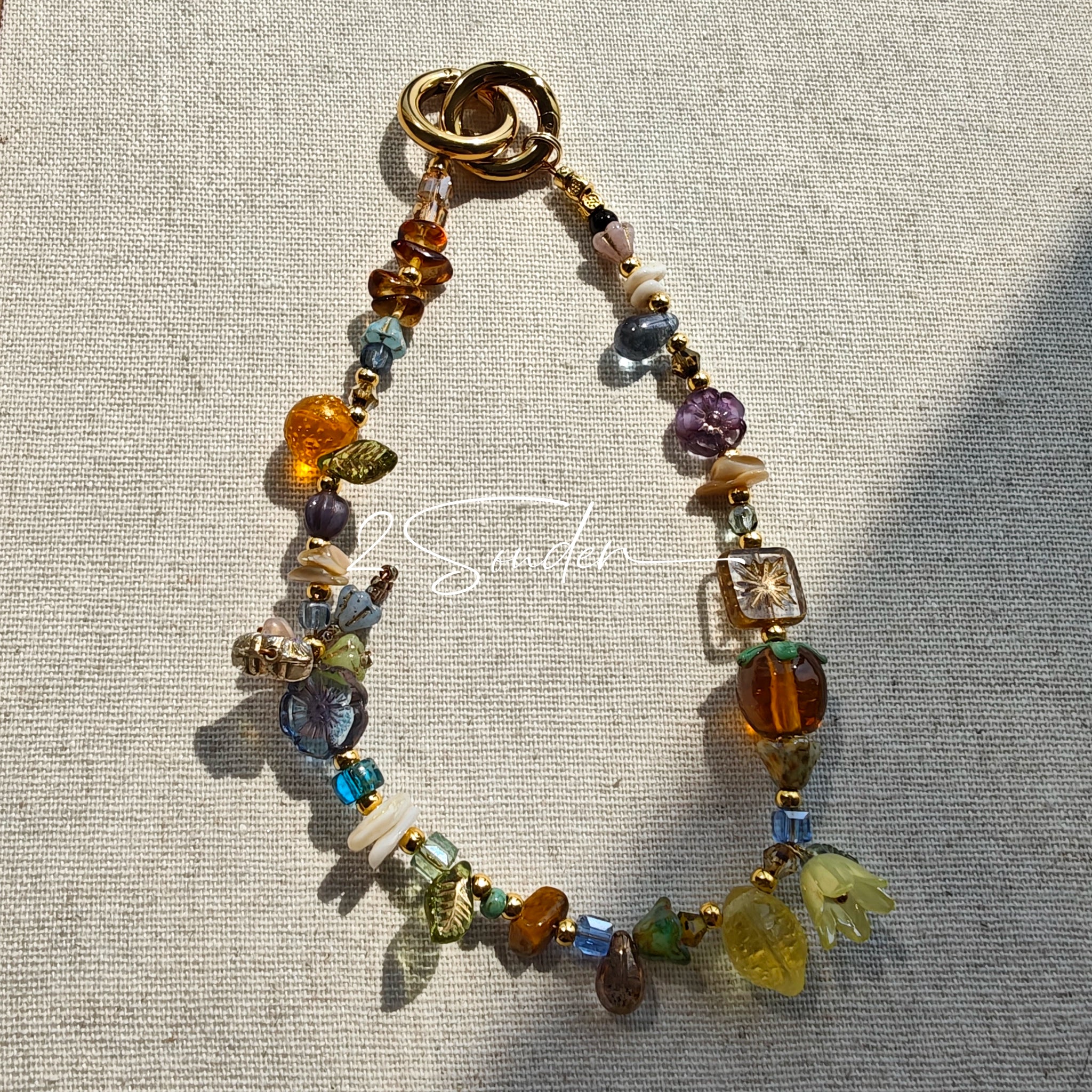 This is a bag charm that made of Czech beads. In the phone strap, there are different spacers like orange, leaves, flowers and lemon. It's with multi colors. This bag charm can also be used as a phone strap and key chain.