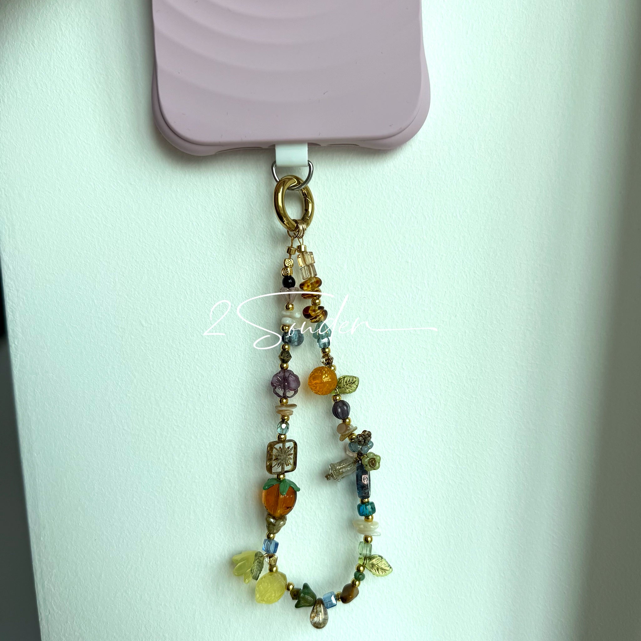 This is a bag charm that made of Czech beads. In the phone strap, there are different spacers like orange, leaves, flowers and lemon. It's with multi colors. This bag charm can also be used as a phone strap and key chain.