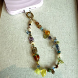 This is a bag charm that made of Czech beads. In the phone strap, there are different spacers like orange, leaves, flowers and lemon. It's with multi colors. This bag charm can also be used as a phone strap and key chain.