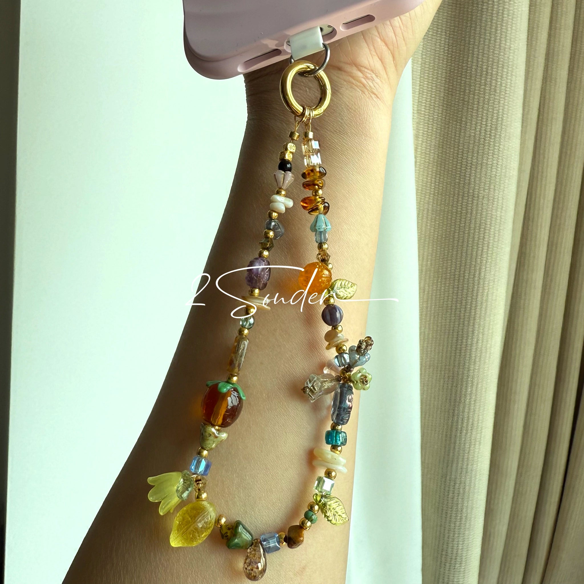 This is a bag charm that made of Czech beads. In the phone strap, there are different spacers like orange, leaves, flowers and lemon. It's with multi colors. This bag charm can also be used as a phone strap and key chain.
