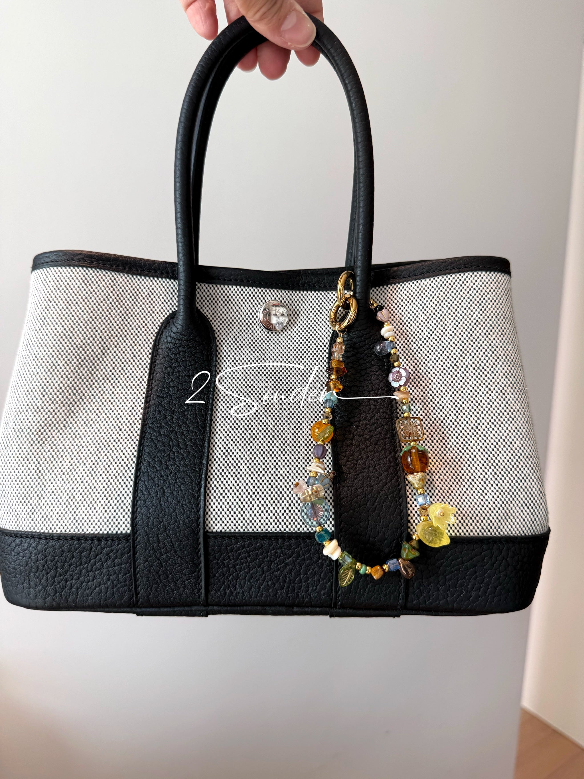 This is a bag charm that made of Czech beads. In the phone strap, there are different spacers like orange, leaves, flowers and lemon. It's with multi colors. This bag charm can also be used as a phone strap and key chain.