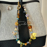 This is a bag charm that made of Czech beads. In the phone strap, there are different spacers like orange, leaves, flowers and lemon. It's with multi colors. This bag charm can also be used as a phone strap and key chain.