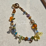 This is a bag charm that made of Czech beads. In the phone strap, there are different spacers like orange, leaves, flowers and lemon. It's with multi colors. This bag charm can also be used as a phone strap and key chain.