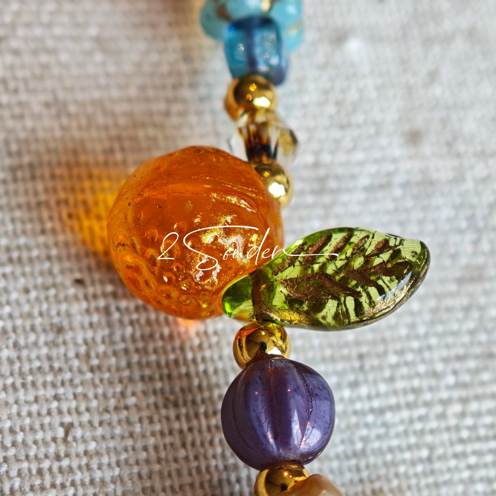 This is a bag charm that made of Czech beads. In the phone strap, there are different spacers like orange, leaves, flowers and lemon. It's with multi colors. This bag charm can also be used as a phone strap and key chain.