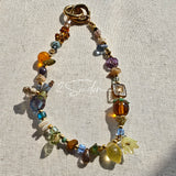 This is a bag charm that made of Czech beads. In the phone strap, there are different spacers like orange, leaves, flowers and lemon. It's with multi colors. This bag charm can also be used as a phone strap and key chain.