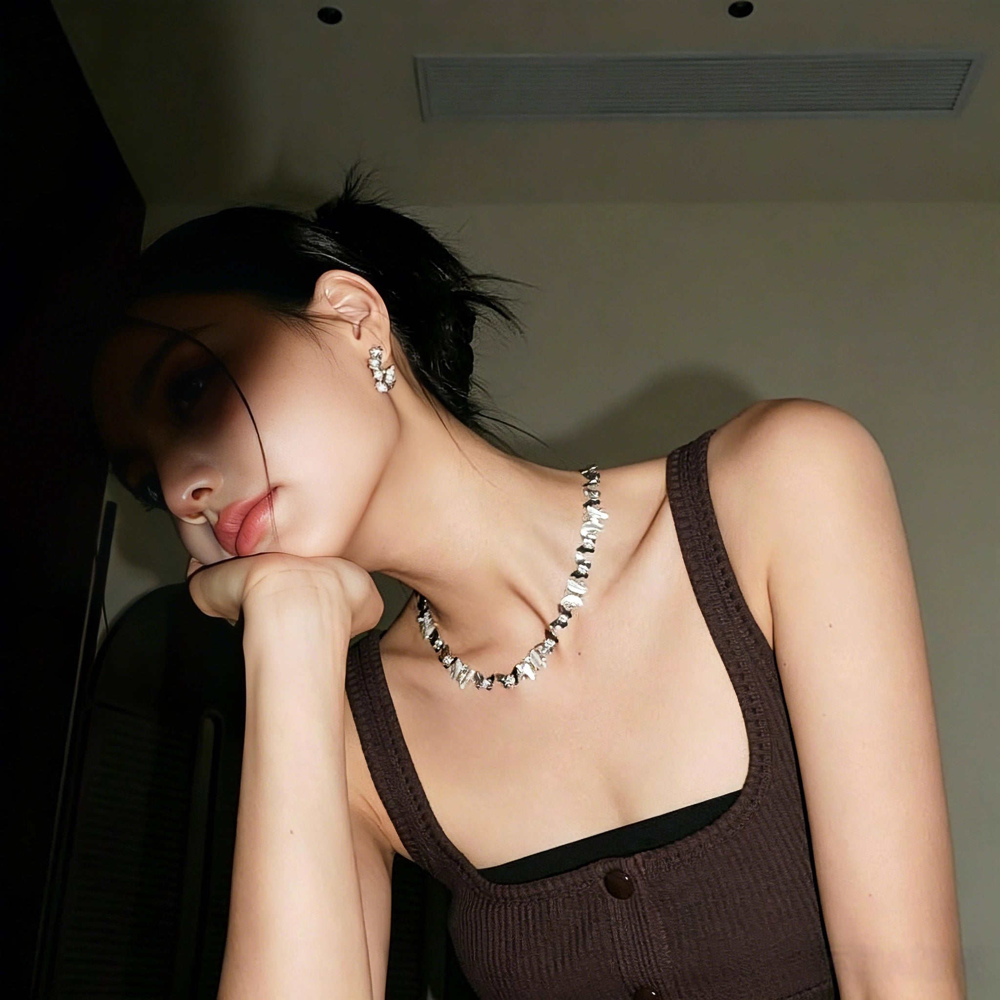 This delicate choker necklace features alternating polished metal butterflies and lustrous white mother-of-pearl butterflies, accented with tiny sparkling crystals. The shimmering white shell inlays contrast beautifully with the warm gold (or cool silver) metal finish, creating an elegant, whimsical design that sits close to the collarbone.
