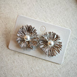 These earrings perfectly blend delicate flowers with lustrous pearls, exuding timeless romance and adding an elegant touch to any outfit.