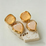 These French vintage-style drop earrings feature a geometric design, crafted with polished gold-tone metal settings. Each earring is adorned with two linked gemstone pendants: a cushion-cut square top and a heart-shaped bottom, made from natural agate in rich, varied hues like warm orange, deep blue, forest green, and vibrant red. The elegant, retro silhouette blends classic charm with a bold, colorful aesthetic, perfect for adding a statement touch to any look.