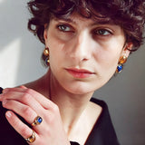 These French vintage-style drop earrings feature a geometric design, crafted with polished gold-tone metal settings. Each earring is adorned with two linked gemstone pendants: a cushion-cut square top and a heart-shaped bottom, made from natural agate in rich, varied hues like warm orange, deep blue, forest green, and vibrant red. The elegant, retro silhouette blends classic charm with a bold, colorful aesthetic, perfect for adding a statement touch to any look.