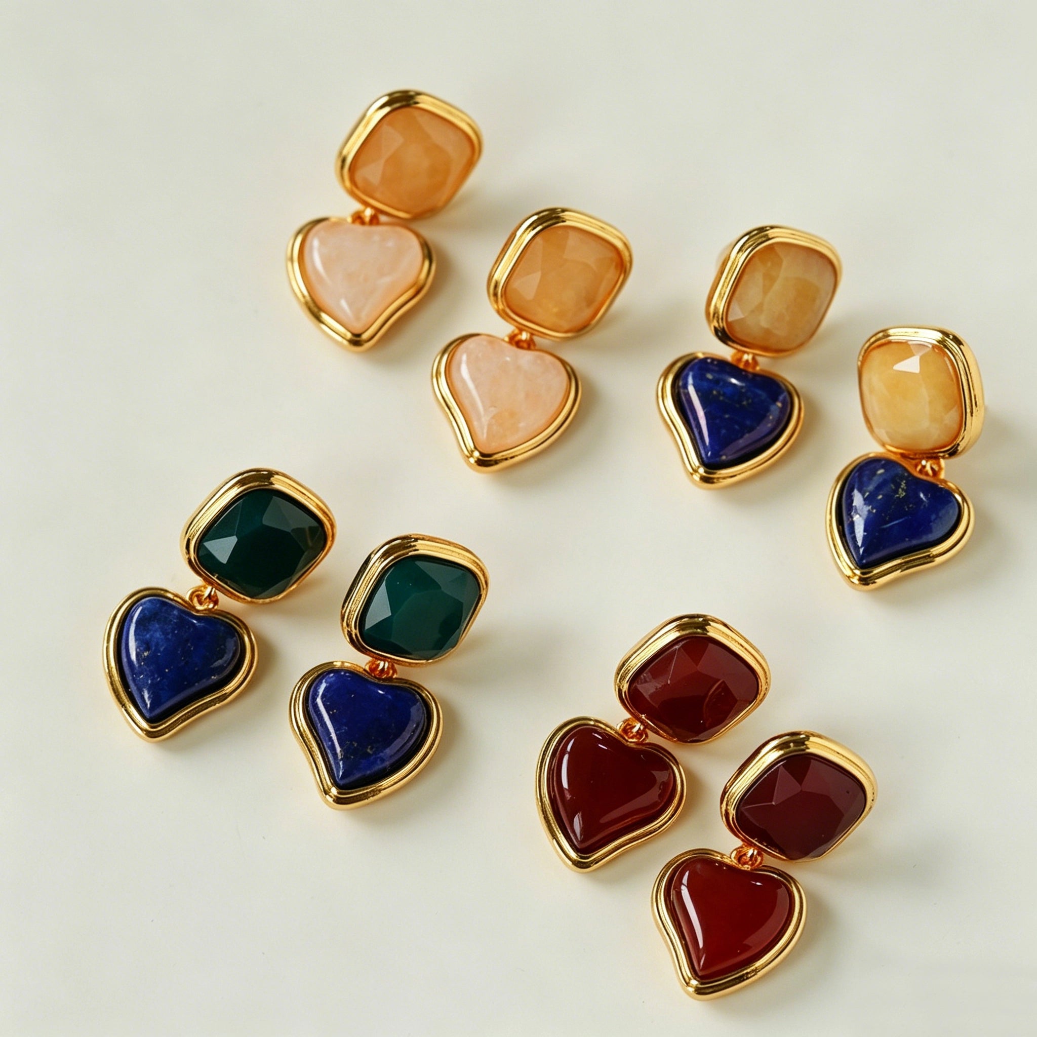 These French vintage-style drop earrings feature a geometric design, crafted with polished gold-tone metal settings. Each earring is adorned with two linked gemstone pendants: a cushion-cut square top and a heart-shaped bottom, made from natural agate in rich, varied hues like warm orange, deep blue, forest green, and vibrant red. The elegant, retro silhouette blends classic charm with a bold, colorful aesthetic, perfect for adding a statement touch to any look.