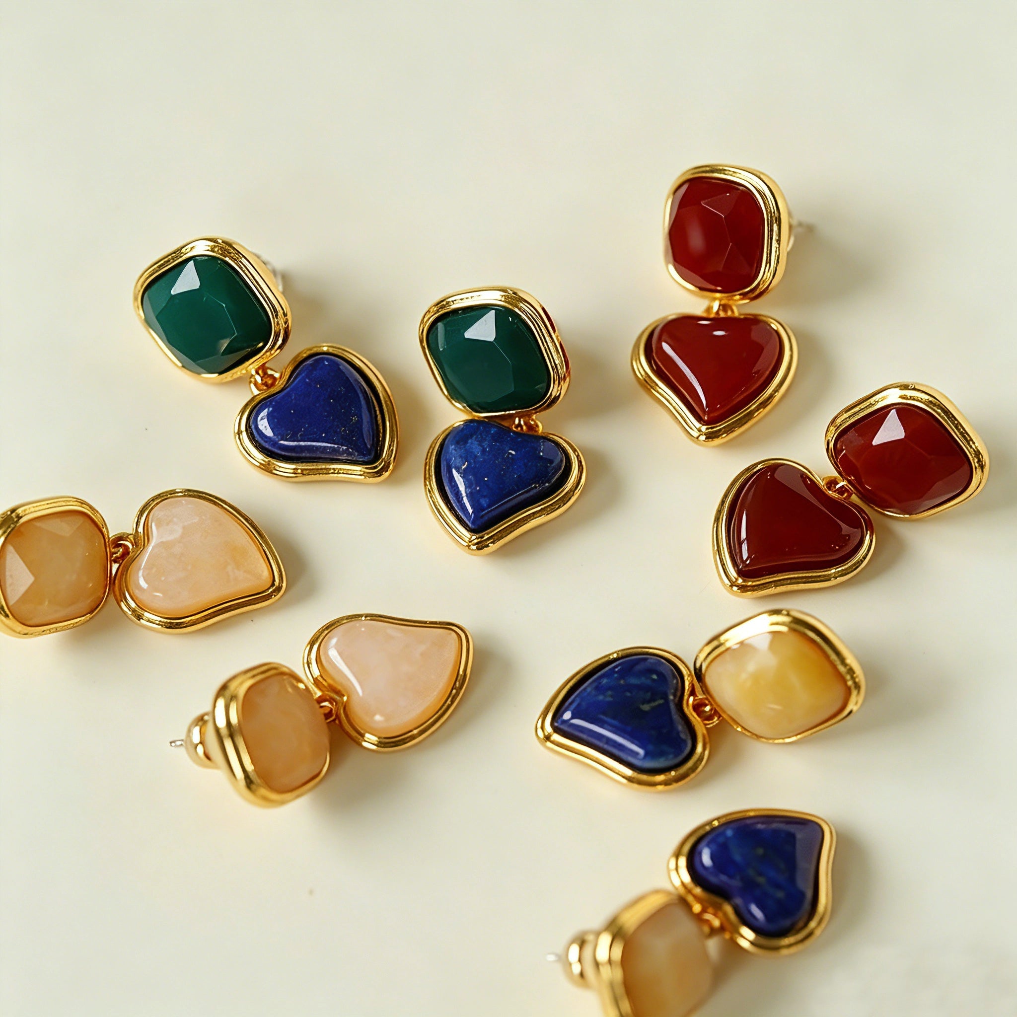 These French vintage-style drop earrings feature a geometric design, crafted with polished gold-tone metal settings. Each earring is adorned with two linked gemstone pendants: a cushion-cut square top and a heart-shaped bottom, made from natural agate in rich, varied hues like warm orange, deep blue, forest green, and vibrant red. The elegant, retro silhouette blends classic charm with a bold, colorful aesthetic, perfect for adding a statement touch to any look.
