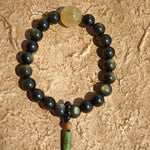 Radiant gold- and silver-obsidian orbs, a single rutile bead, and a sandalwood-agate pendant meld into a protective, culturally rich bracelet.