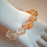 This is a gemstone bracelet made of Golden Hematoid Quartz, Copper Rutilated Quartz, Clear Quartz and Citrine. In the bracelet, there is also a bow pendant as decoration.