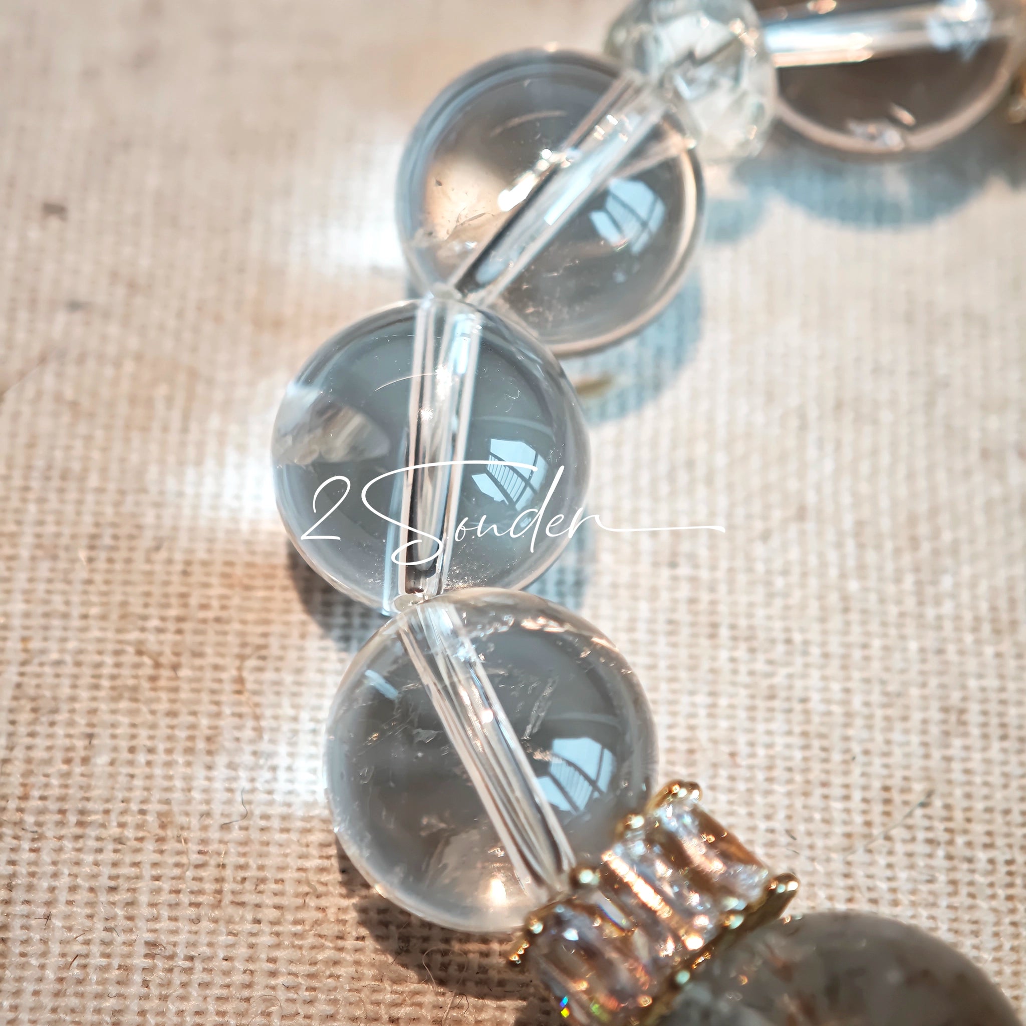 This is a gemstone bracelet made of Golden Hematoid Quartz, Copper Rutilated Quartz, Clear Quartz and Citrine. In the bracelet, there is also a bow pendant as decoration.