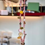This is a pink czech beads bracelet, decorated with green leaves , yellow lemon, flowers and irregularly shape amber color beads.