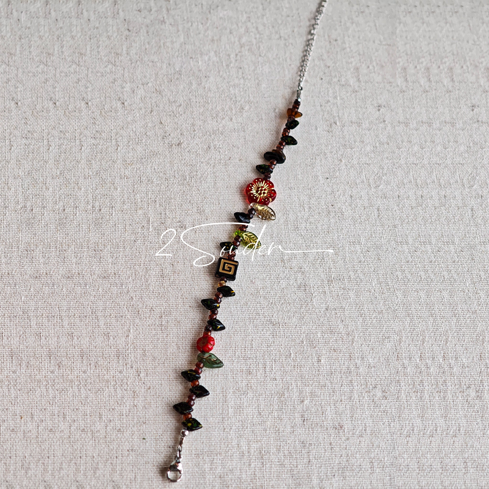 This is a bracelet crafted with rich terracotta glass beads that glow like aged parchment. It captures the warmth of a late autumn sunset. In the bracelet, there are various leaves, flowers, and irregularly shaped spacers. It’s the perfect piece of vintage jewelry to add a touch of nostalgia to your daily rotation.